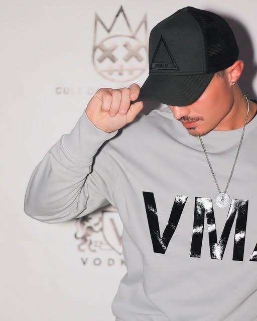 Leon Budrow in a gray sweatshirt and black cap at a branded event