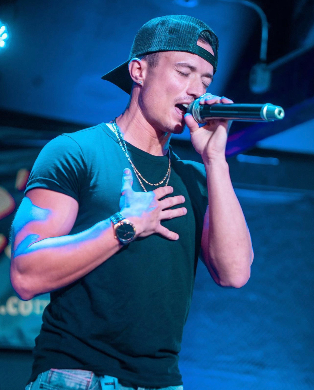Leon Budrow singing under blue stage light